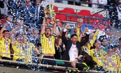 Oxford’s Elliott Moore lifts the playoff final trophy after beating Bolton