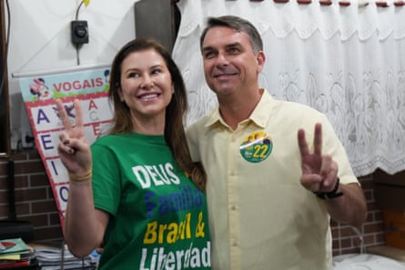 Bolsonaro and his wife, Fernanda, flash peace signs and smile