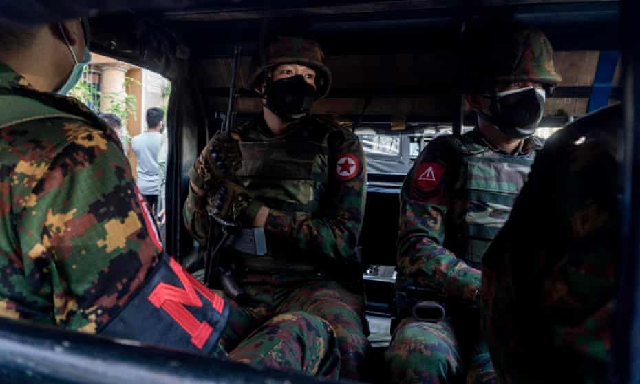 Myanmar soldiers sit inside a military truck outside a Hindu temple in Yangon on Tuesday