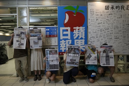 Staff members from Hong Kong’s Apple Daily pose at newspaper’s headquarters in June 2021.