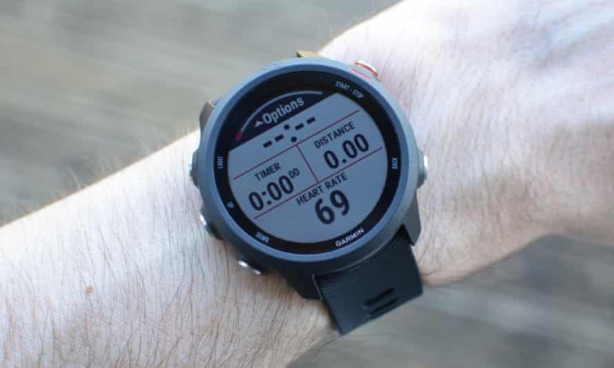 A Garmin Forerunner 245 on a wrist showing running stats.