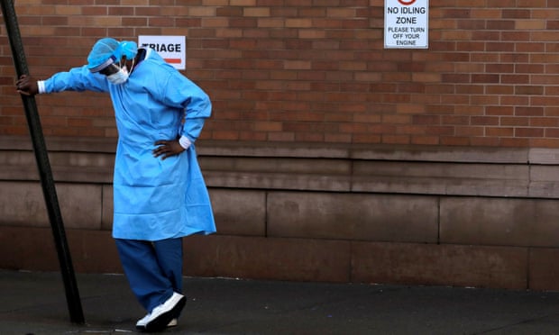 A healthcare worker takes a break outside the emergency center at Maimonides medical center in Brooklyn, New York.