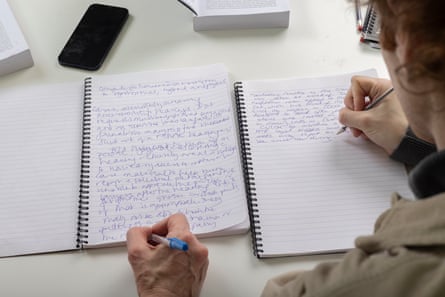 Over-the-shoulder shot of Francis Lee writing on a page with Williams’s hand and note pad visible beside