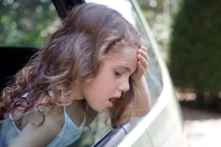 A little girl leaning out of the window looking sick