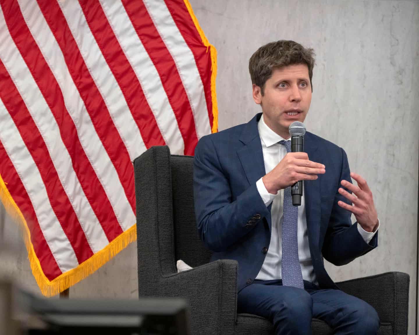Government official discusses AI regulation, US flag in background