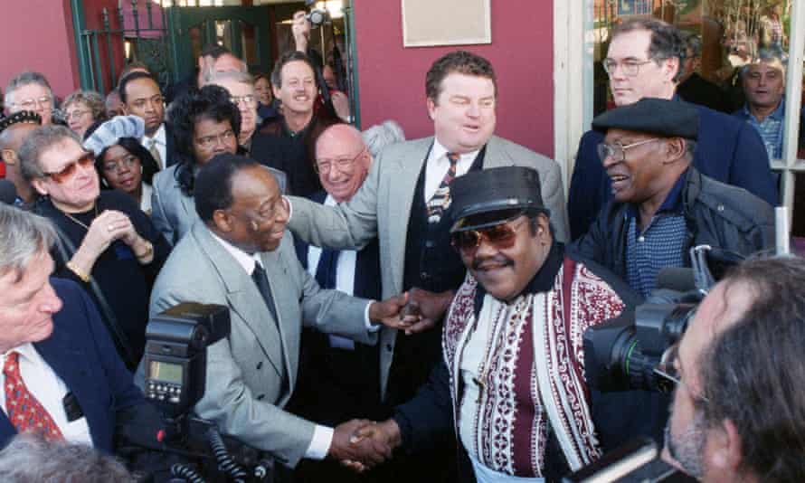 Fats Domino, center right, shakes hands with Dave Bartholomew, left, amid a crowd of former colleagues at the 50th anniversary observance of Domino's first recording session in New Orleans, December 1999.