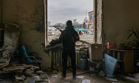 A member of the territorial defence forces of Ukraine stands inside the damaged Kharkiv regional administration building in the aftermath of a shelling.