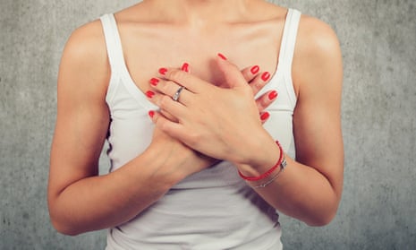 Stock image of woman holding hands on chest suffering from pain