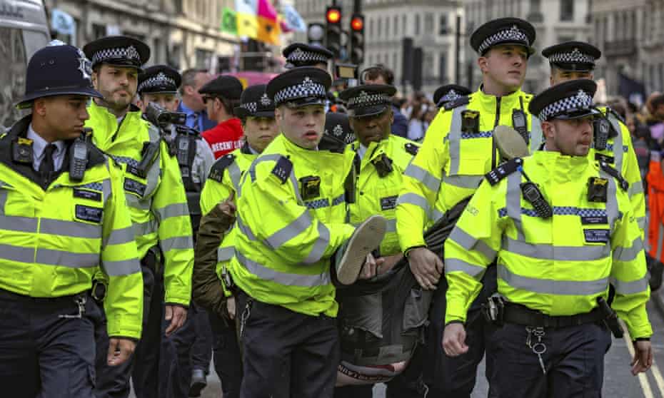 Police arrest protesters as they block traffic in Oxford Circus.