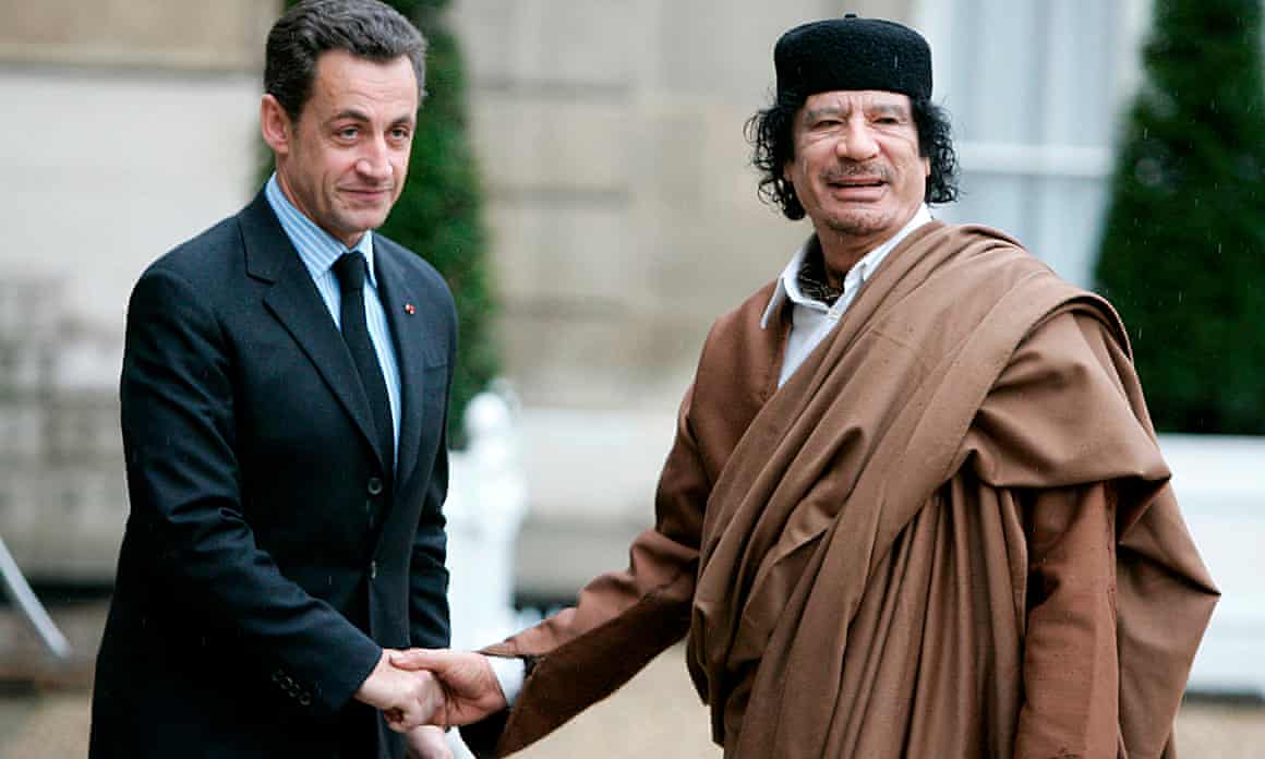 Sarkozy shakes hands with Gaddafi