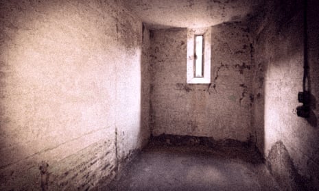 An empty cell with bare walls and a slit for a window