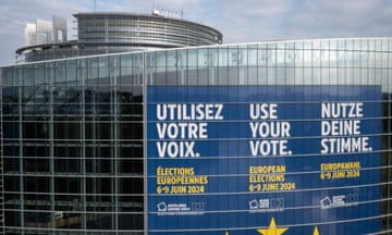 A giant poster on the facade of the European parliament building in Strasbourg, eastern France, reads in French, German and English: Use Your Vote and gives the dates of the election. The poster in dark blue with white and yellow lettering, and the yellow stars of the EU flag are seen below. The building is a modern steel and plate-glass construction.