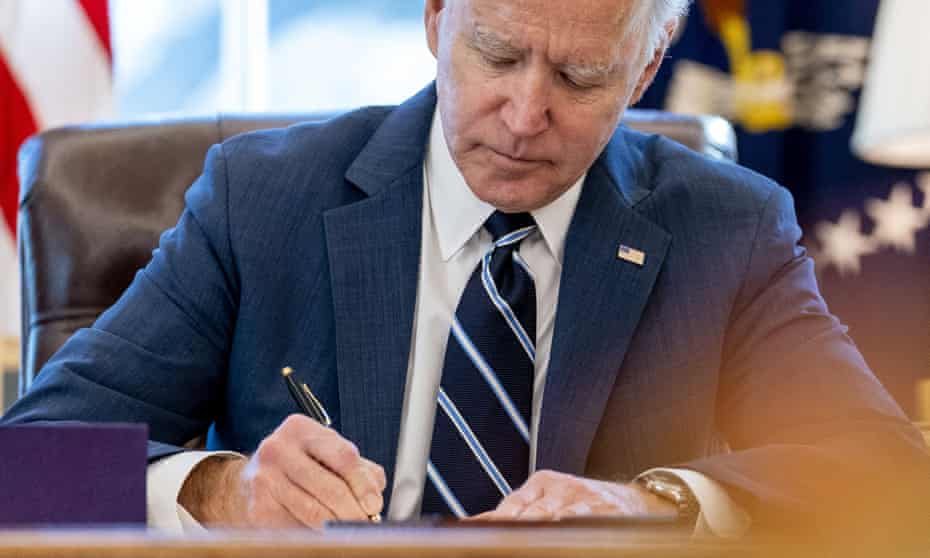 Joe Biden signs the American Rescue Plan in the Oval Office.