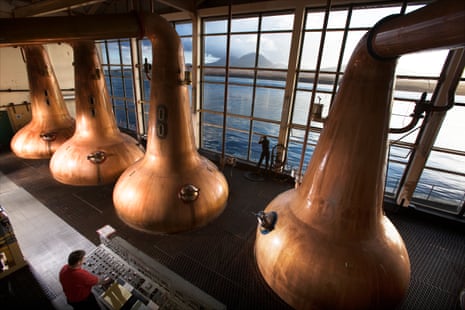 The Caol Ila whisky distillery on the Isle of Islay.the still men at Caol Ila scotch whisky distillery, pause at dawn, to take in the view. The stills are of traditional shape. The tall windows of the stillroom overlook the Sound of Islay with Jura and the Paps of the Jura in the background.