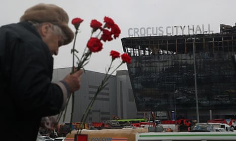 People bring flowers at the Crocus City Hall concert venue following a terrorist attack in Moscow, Russia.
