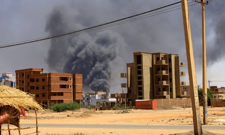 Smoke rises between two buildings in Khartoum North