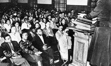 black and white picture of people sitting in an assembly room
