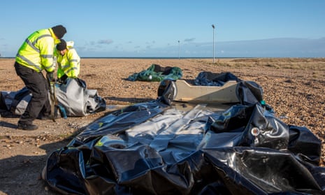 Workers outside the RNLI station in Dungeness, Kent, load up deflated dinghies used to transport people across from France.