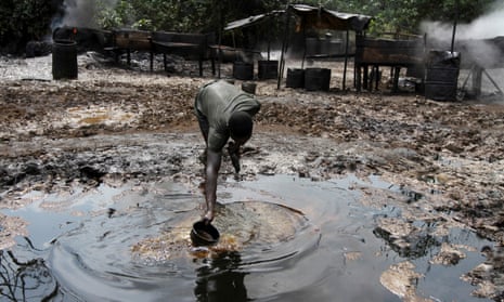 A man collecting polluted water at an illegal oil refinery site near river Nun in Bayelsa.