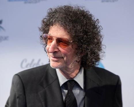 a man in a suit and sunglasses looks to the side