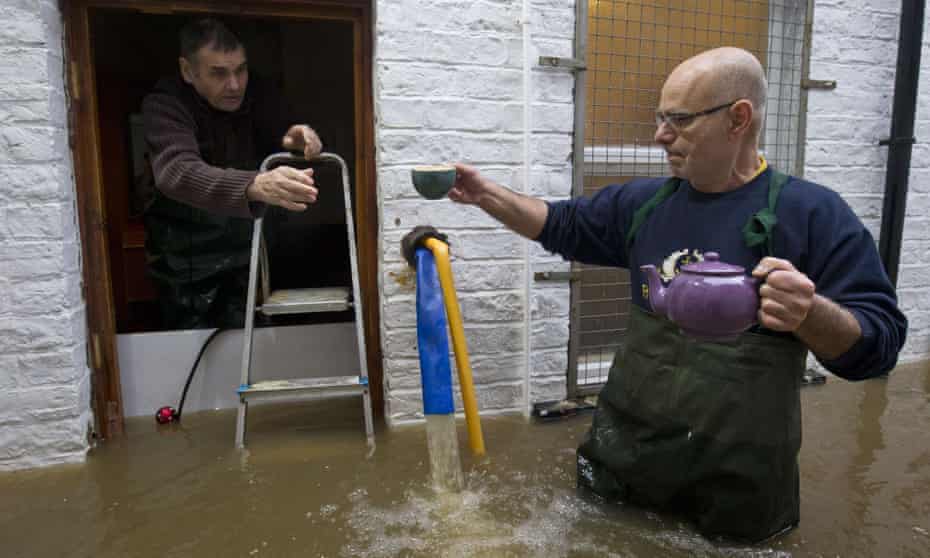 I could do with a brew: workers from a taxi firm share a cuppa after floodwaters from the rivers Foss and Ouse burst their banks in York.