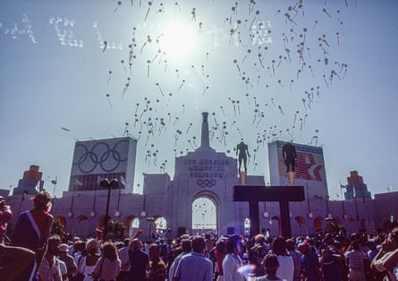 Balloons over a stadium as a crowd stands by