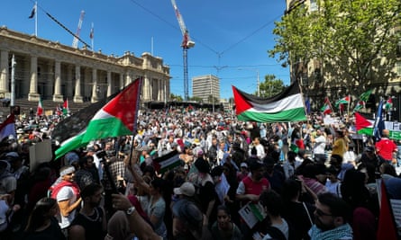 عشرات الآلاف من المتظاهرين المؤيدين للفلسطينيين في وسط مدينة ملبورن، يحملون لافتات وأعلام فلسطينية