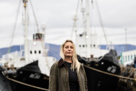 A middle-aged woman in a port looks at the camera