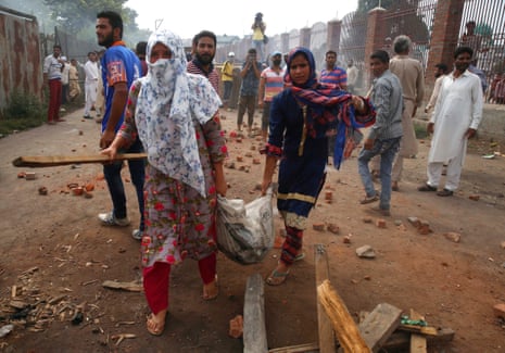 Kashmiri women girls carry a bag filled with bricks and stones to help protesters during clashes with Indian forces in in Anchar,