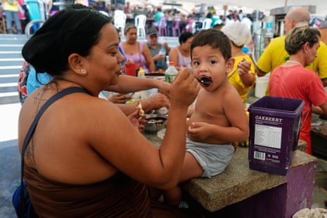A woman feeds acai to her child at a market in Belém, Brazil.