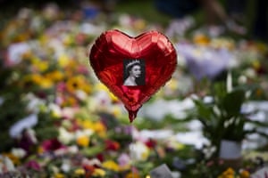 A balloon with a picture of Queen Elizabeth II hovers over flowers at the Green Park memorial