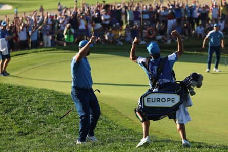Jon Rahm and his caddie celebrate on the 16th green during the Friday afternoon fourballs