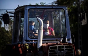 A family ride their tractor through the countryside outside Havana