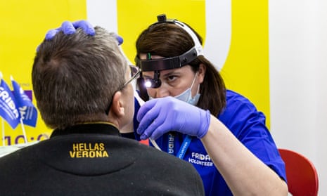 یک پزشک داوطلب FRIDA اوکراین بیمار خود را در یک مرکز سرپایی در Dream Berry در کیف معاینه می کند.