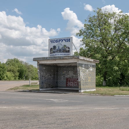 A grey shelter on a corner of a crossroads