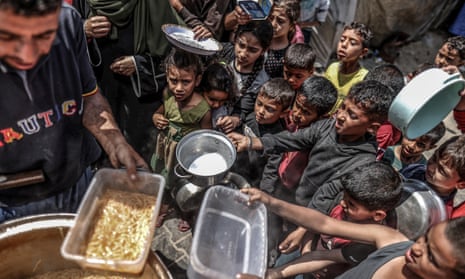 Palestinian children in Khan Younis queue for hot food.