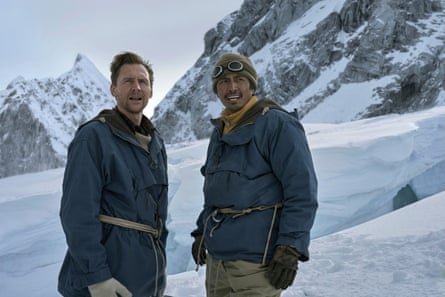 Two men in climbing gear against a dramatic snowy backdrop