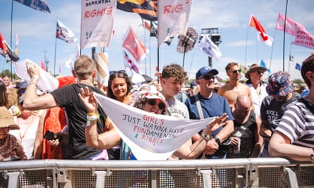 A fan holds a banner referencing Lauper’s slogan.
