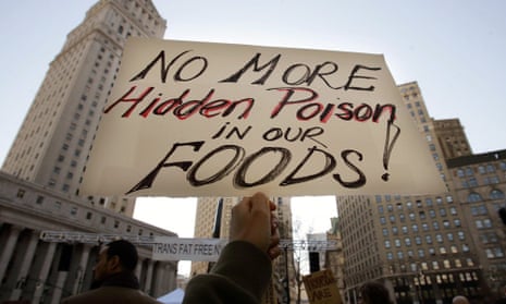 A protester holds a sign reading “No More Hidden Poison in Our Foods” at a rally against trans fats in 2006 in New York City