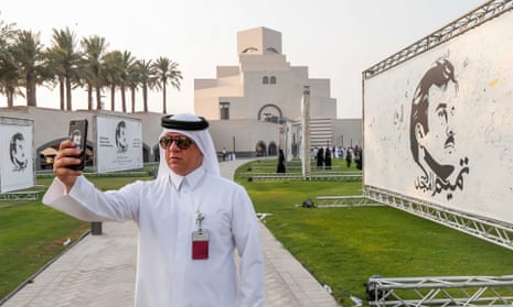 A visitor takes a selfie during an exhibition of artworks Doha Qatar