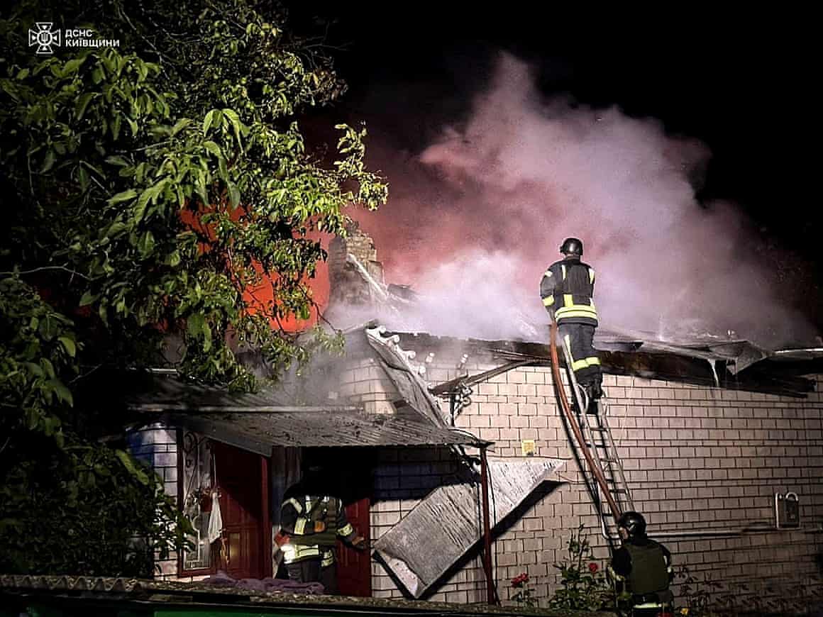 Firefighters work at the site of a residential building damaged during a Russian drone strike.