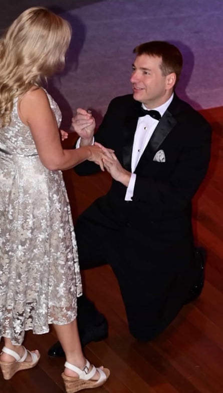 جيف وهو على ركبته holding a ring to put on Debb's finger