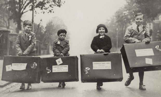 Four children carrying large suitcases 