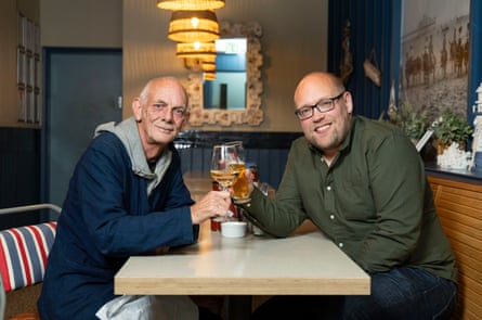 Andrew and Jonathan holding up their drinks and smiling at the camera