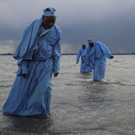 Senior members leave the sea after leading the mass baptism