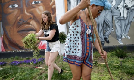 Loyola University students Kate Spence, 21, and Kassina Dwyer, 18, work to clear and landscape the garden in front of a large memorial mural of Freddie Gray on Tuesday in Baltimore, Maryland.