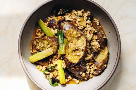 Overhead shot of fried and braised eggplant with crumble tofu and shallot batons, in a grey bowl.