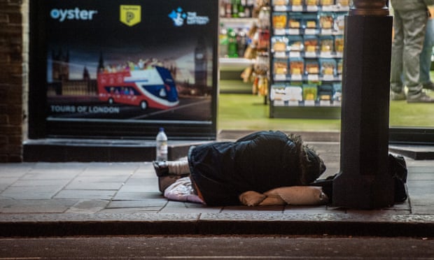 A homeless person sleeps on a London street.
