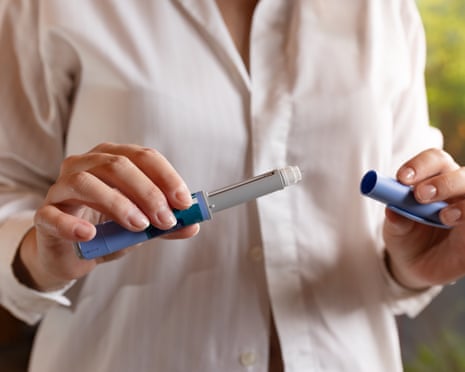 A woman holding a weight-loss drug injection pen