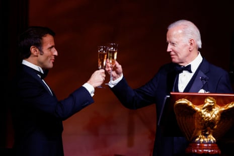 Joe Biden and Emmanuel Macron raise glasses to each other.